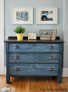 a blue dresser with two pictures on the wall above it and a potted plant