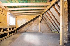 an unfinished room with exposed walls and wooden beams