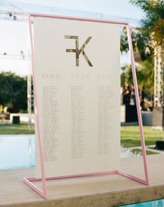 a pink and white sign sitting on top of a pool