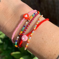 seed bead bracelet with a cute heart bead. red with pink heart. neon pink with red heart. strung on elastic please gently roll off and on to prolong its life handmade in venice, ca Pink Playful Heart Beads Friendship Bracelets, Playful Pink Heart Beads Friendship Bracelets, Playful Pink Friendship Bracelets With Heart Beads, Trendy Red Beaded Bracelets With Tiny Beads, Fun Red Jewelry For Friendship, Red Letter Beads For Friendship, Fun Red Jewelry With Colorful Beads, Cute Red Beaded Bracelets With Heart Beads, Cute Red Beaded Bracelet With Heart Beads