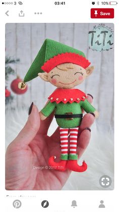 a hand holding a small christmas elf doll