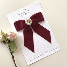 "Make a statement with our enchanting short tail burgundy velvet hair bow, embellished with a shimmering pearl and rhinestone button. Available as a clip, bobble, or barrette, this accessory is a perfect blend of sophistication and sparkle, designed to elevate your style effortlessly. ✨ Key Features: - Luxe Velvet: Immerse yourself in the velvety softness of our premium velvet, creating a short tail bow that feels as luxurious as it looks. - Pearl and Rhinestone Elegance: Adorned with a radiant pearl and rhinestone button, this bow adds a touch of glamour to your hairstyle, making it perfect for special occasions. - Measurements: Approx 6\" tall and 5\" wide. 📌 Versatile Styling Options: Clip: Secure the bow with ease for a classic and timeless look, enhanced by the dazzling button that c Velvet Hair Bow, Bow Tie Hair, Ribbon Brooch, Velvet Bows, Ribbon Crafts Diy, Tail Hair, Clip Design, Pearl Bow, Velvet Shorts