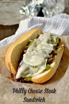 a close up of a sandwich on wax paper with the words phily cheese steak sandwich