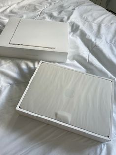 an apple box sitting on top of a bed next to another box with the lid open