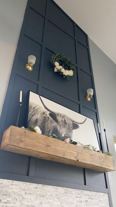 a cow head is mounted on the wall above a mantle