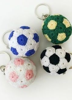 three crocheted keychains with soccer balls on them sitting next to each other