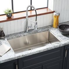 a stainless steel sink in a kitchen with granite counter tops