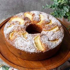 a cake on a wooden platter with powdered sugar