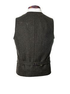 It's timeless quality makes this Irish tweed waistcoat well worth investing in if you have a penchant for classic Irish Design. This handmade tweed vest has an earthy tonal composition making it perfect for both day and evening events. The traditional herringbone peat colored tweed contains flecks of green and brown, for an immediate feel of the Irish landscape. Cut with quirky design details, it has been designed with a nod to Irish historical events. This fabric champions versatility offering Business Tailored Tweed Vest, Tailored Classic Tweed Vest, Classic Tweed Vest For Work, Elegant Tweed Business Vest, Elegant Tweed Vest For Business, Classic Wool Winter Vest, Classic Wool Vest For Winter, Winter Classic Wool Vest, Formal Brown Tweed Vest