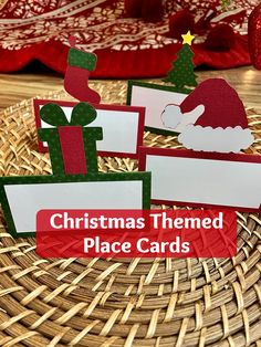 three christmas themed place cards sitting on top of a wicker basket with red and green decorations