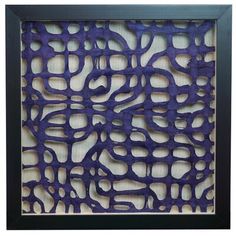 an art piece is shown in a black frame with purple paper cut outs on it