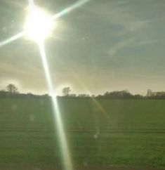 the sun shines brightly over an open field