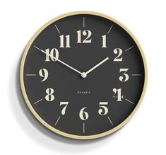 a black and gold clock with numbers on the face is shown against a white background