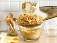 a spoon full of sprinkles on top of a table