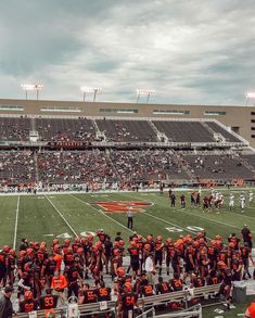 the football team is standing on the sidelines in front of an empty bleachers