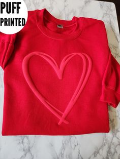 a red shirt with a heart drawn on it and the words puff printed above it