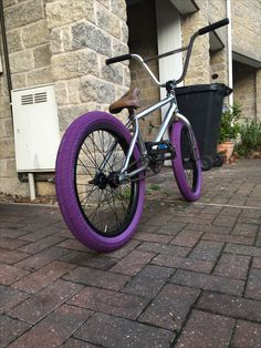 a bike with purple tires is parked in front of a building