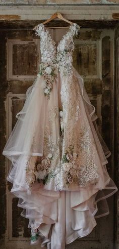 a dress hanging on a door with flowers and ribbons around the neck, as if it were made out of tulle