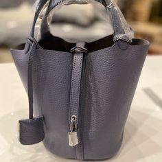 Color: Grey-Blue Approximate: Please See The Pictures Brand New Without Tag Leather: Cowhide Silver-tone Hardware Pouch Bag For Daily Use, Daily Use Pouch Bag With Silver-tone Hardware, Luxury Blue Bucket Bag For Daily Use, Luxury Blue Bucket Bag For Shopping, Blue Top Handle Bucket Bag For Evening, Blue Bucket Bag With Detachable Handle For Evening, Evening Blue Bucket Bag With Detachable Handle, Blue Evening Bucket Bag With Detachable Handle, Blue Textured Leather Shoulder Bag For Shopping