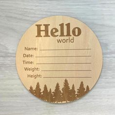 a wooden name tag that says hello world with trees on the front and back of it