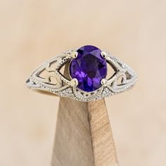 an oval shaped amethorate ring with filigrees on the sides