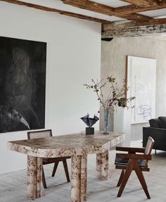 a table and chairs in a room with white walls