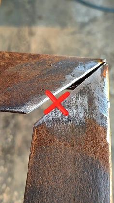 a close up of a piece of metal with a red x mark on the end