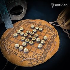 a wooden board game set up on top of a table with some metal objects around it