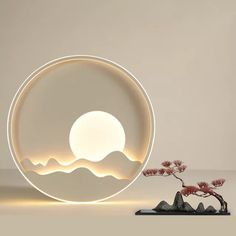 a small bonsai tree in front of a circular light