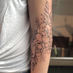 a woman's arm with a flower tattoo on the left side of her arm