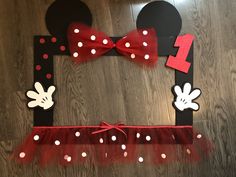 a mickey mouse frame with red and white polka dot tulle on the bottom, minnie mouse ears at the top