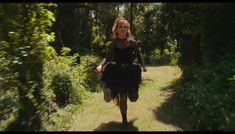 a woman is running down a path in the woods