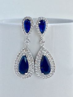 Absolutely stunning!! blue sapphire cubic zirconia large teardrop bridal earrings in rhodium plated brass setting. Earrings feature a large teardrop with pear cut blue sapphire cubic zirconia center surrounded by two rows of clear zirconia crystals. Teardrop dangles from a blue sapphire cubic zirconia teardrop ear stud. Total length of the earrings is 5.5 cms. To browse my collection click : https://www.etsy.com/your/shops/fantasycrystals Gold Bridesmaid Jewelry, Teardrop Bridal Earrings, Bridal Jewelery, Blue Crystal Earrings, Pearl Jewelry Sets, Halo Earrings, Bridesmaid Jewelry Sets, Cubic Zirconia Earrings, Purple Crystals