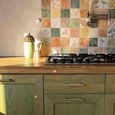 a stove top oven sitting inside of a kitchen next to a wooden counter tops and cabinets