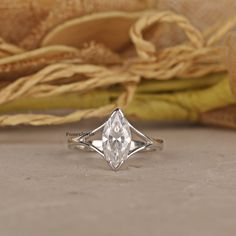 a diamond ring sitting on top of a table next to a cloth and some other items