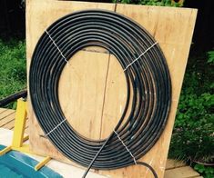 a wooden box with some black wires on it and a blue pool in the background