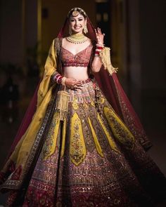 a woman in a yellow and red lehenga with her hands on her hip