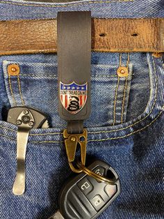 "This belt strap key holder has a cool \"Don't tread on me\" snap closure for fast and easy removal of the strap from your belt. You can also strap it to a purse or backpack. Genuine Top Grain Leather is 1/8\" Thick.  A super heavy duty genuine leather strap to carry your keys on your belt. Thick and durable leather ensures many years of reliable service. This is the perfect accessory for anyone who wants to keep their keys secure and within easy reach. Made from high-quality, genuine leather, this key chain is durable and built to last. The key chain features a sturdy belt loop design, allowing you to attach it to your belt or pants for easy access to your keys. The leather material gives it a classic and stylish look, making it a great addition to any outfit. The key chain is also compac Casual Lanyards With Key Leash For Everyday Use, Casual Lanyard With Key Leash For Everyday Use, Casual Lanyards With Key Leash, Casual Lanyards With Keychain For Everyday Use, Adjustable Badge Holder With Swivel Clip For Everyday, Leather Keychains With Key Leash For Everyday Use, Leather Keychain With Key Leash, Everyday Leather Keychain With Key Clip, Black Keychain With Key Clip For Everyday Use