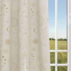 an open window with a curtain in front of it and a field outside the window