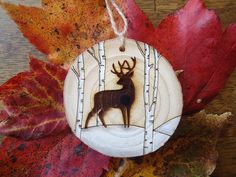 a wooden ornament with an image of a deer in the woods