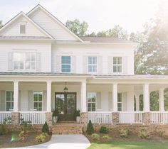 a large white house with columns on the front porch and windows above the entry door