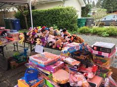 there are many stuffed animals and toys on the table in front of the house that is for sale