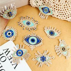 blue and white evil eye brooches are laying on the ground