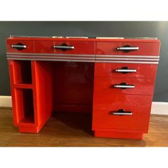 an old fashioned red desk with drawers