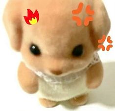 a small stuffed animal with an orange flame on it's head and eyes, sitting in front of a white background