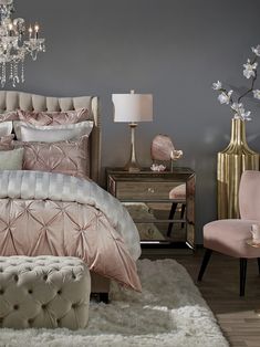 a bedroom with a chandelier and pink bedding