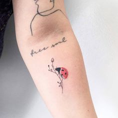 a ladybug tattoo on the left arm with words written in cursive writing