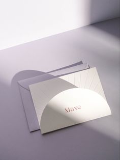 two folded cards sitting next to each other on top of a white table with the word mare printed on it