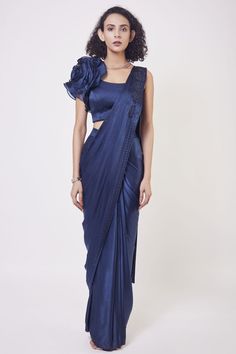 Shop navy blue satin drape dress with a designer blouse and floral design on the shoulder of the blouse. Make a fashion statement on festive occasions and weddings with designer sarees, designer suits, Indian dresses, Anarkali suits, palazzo suits, designer gowns, sharara suits, and embroidered sarees from Pure Elegance Indian fashion store in the USA. Blue Pre-draped Saree With Unstitched Blouse For Designer Wear, Transitional Blue Pre-draped Saree With Unstitched Blouse, Blue Bollywood Fitted Pre-draped Saree, Fitted Blue Bollywood Pre-draped Saree, Navy Blue Drape Saree, Satin Drape Dress, Navy Blue Saree, Blue Drapes, Drape Saree