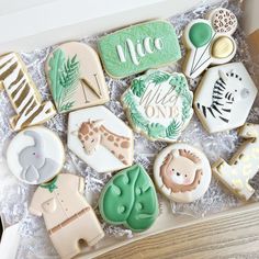 a box filled with lots of decorated cookies in different shapes and designs on top of each other